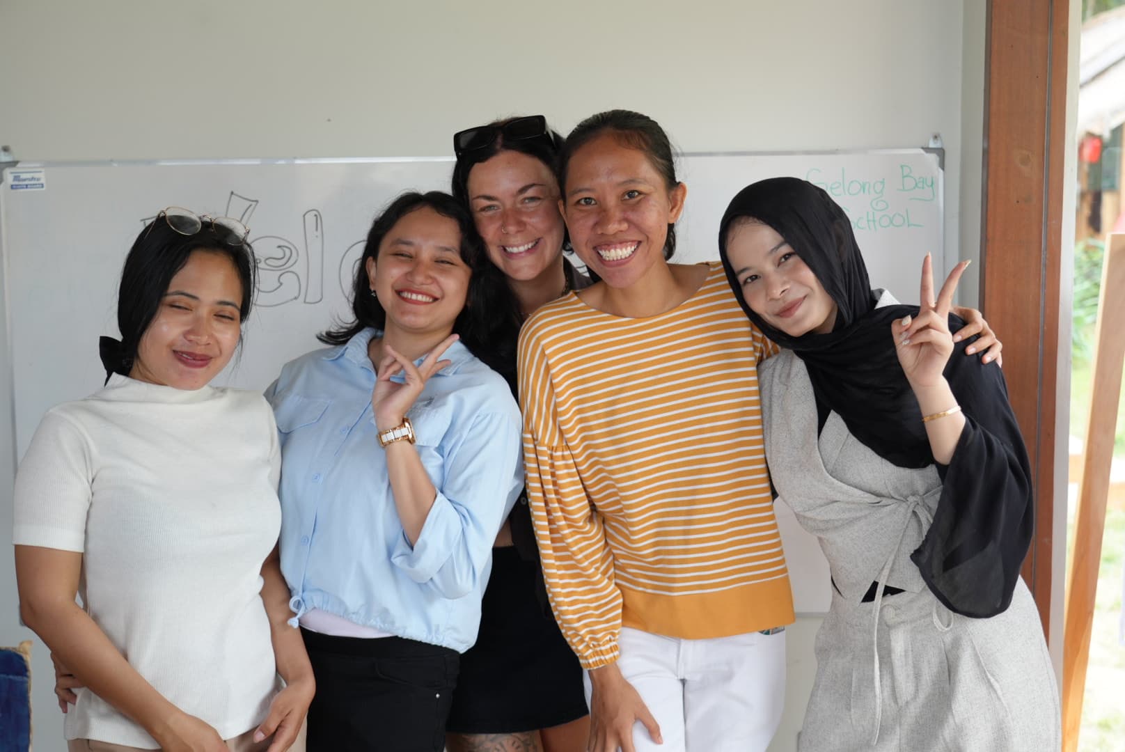Selong Bay School staff smiling together in a classroom