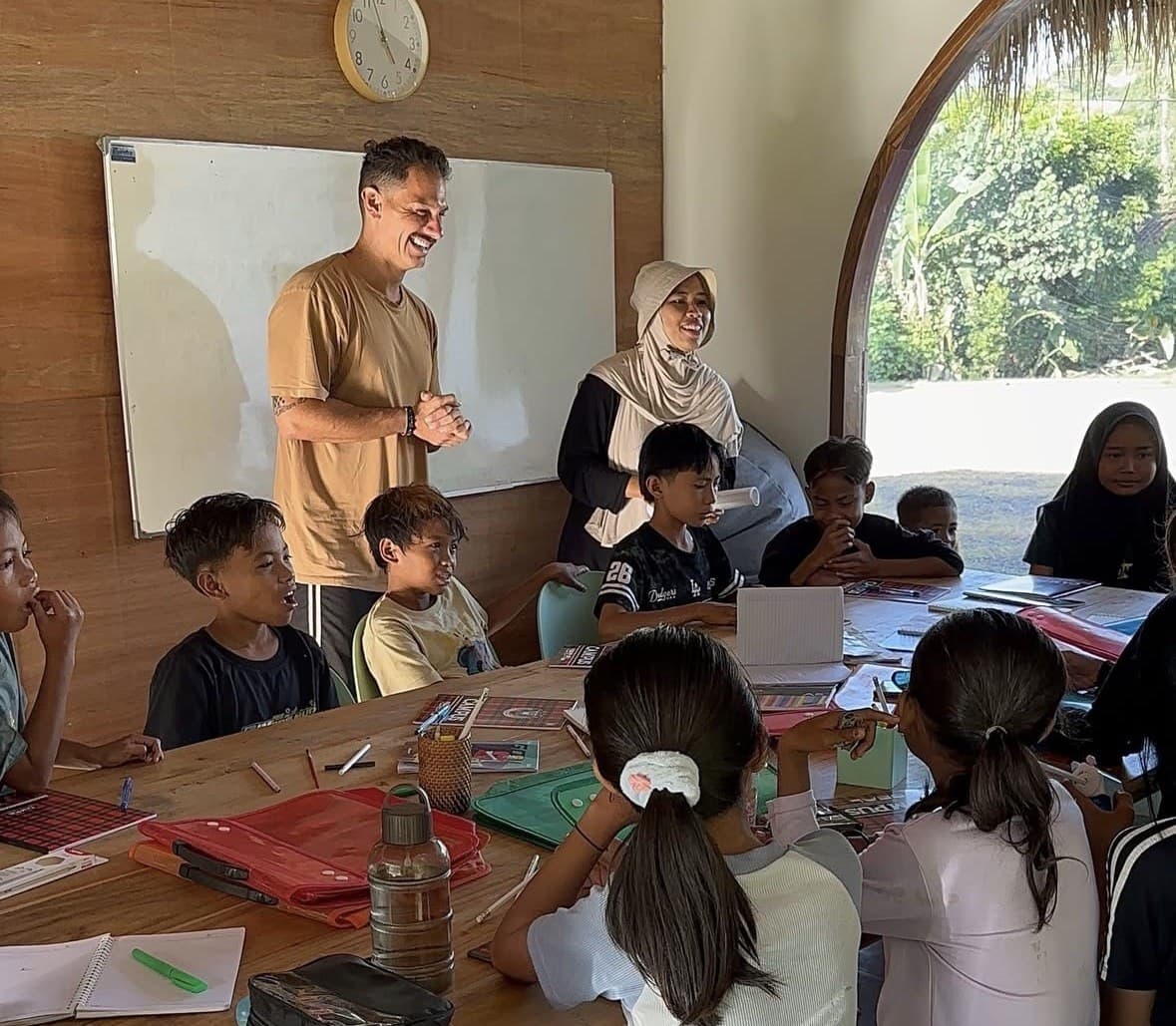 A Selong Bay School teacher and volunteer teaching students at the Serangan English School